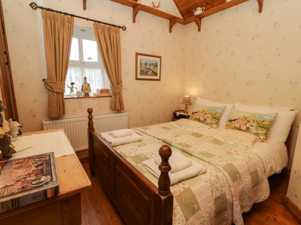 A bedroom with a bed and a window at Teresa's Cottage