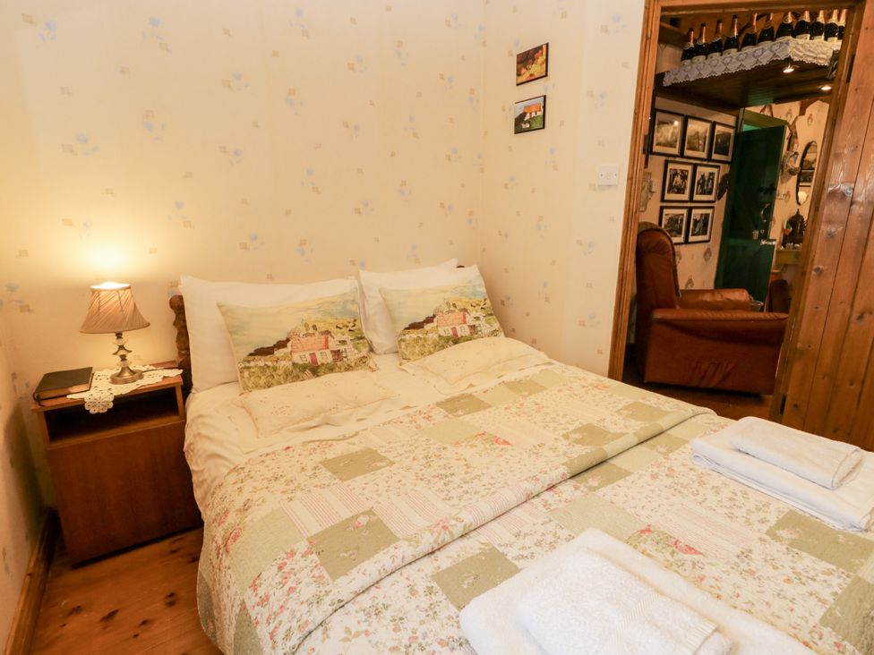 A bedroom with a double bed and bedside table at Teresa's Cottage
