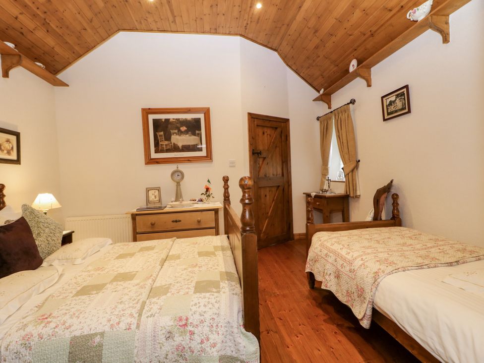 A bedroom with two beds and a nightstand at Teresa's Cottage