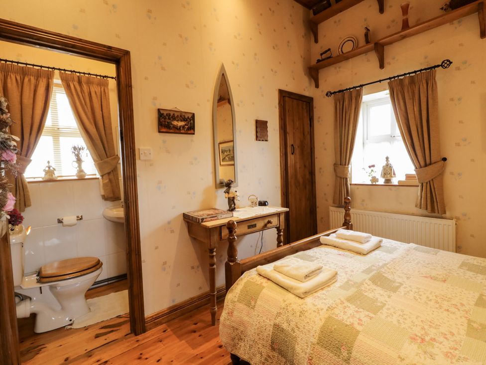 A bedroom with a bed and adjacent bathroom at Teresa's Cottage