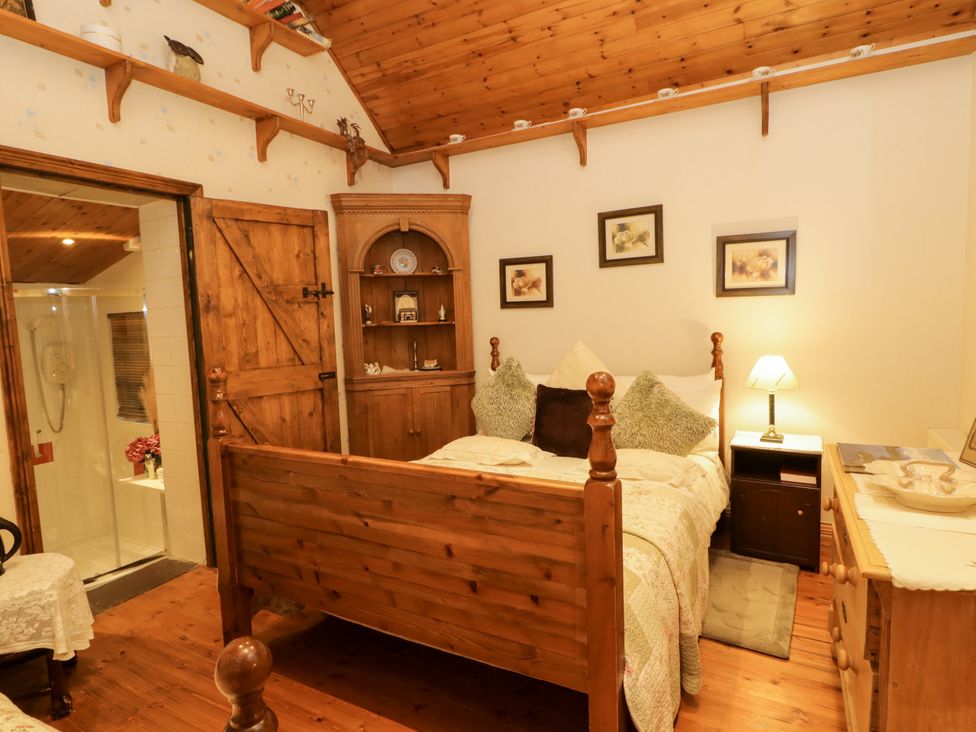 A bedroom with a bed and nightstand at Teresa's Cottage