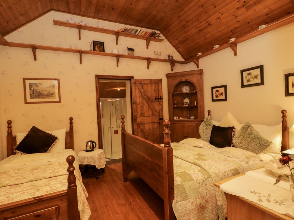 A bedroom with twin beds and a wooden cabinet at Teresa's Cottage