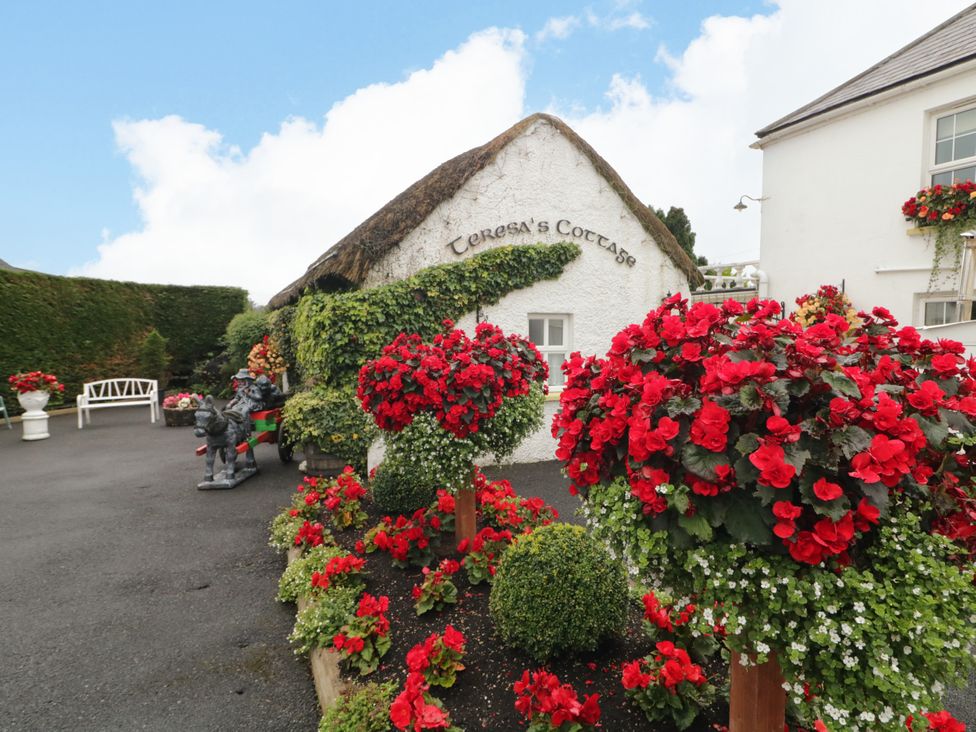 An outdoor view of Teresa's Cottage with flower pots and a decorative garden in 