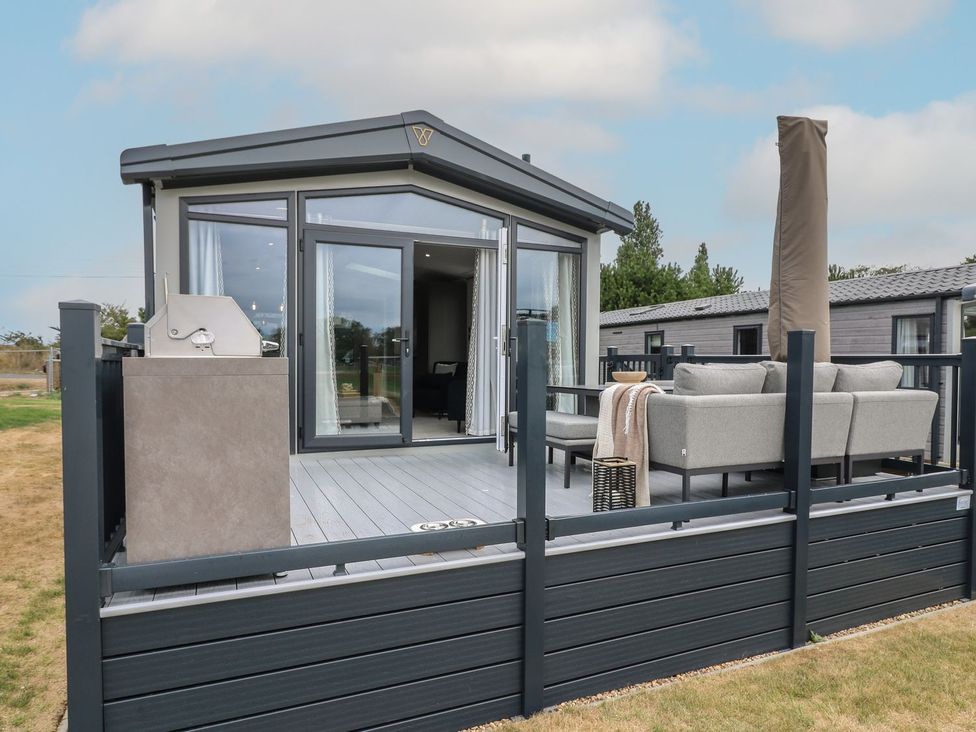An outdoor area with decking and furniture at Lakewood Plot 8 