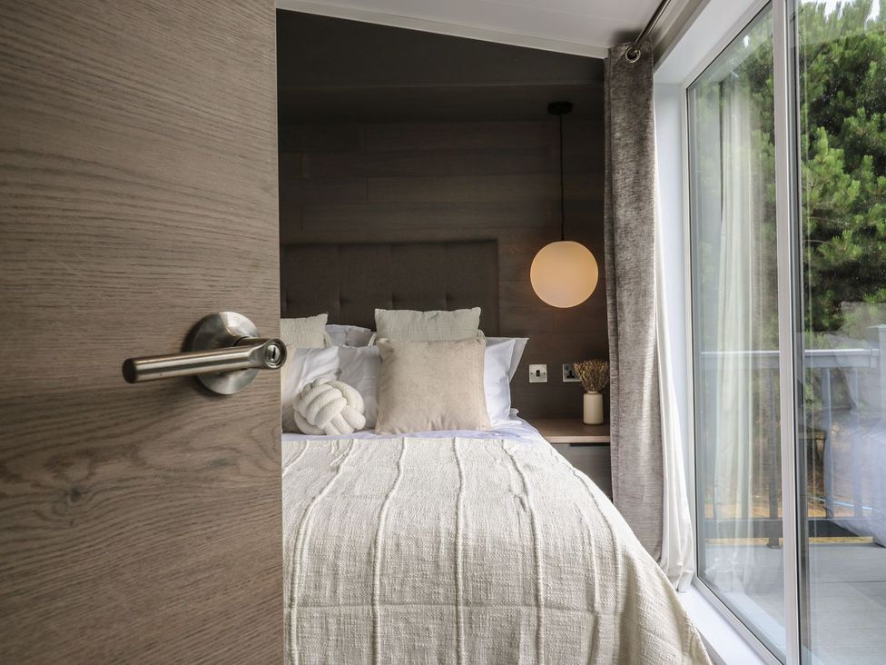 A bedroom with a bed and lamp visible at Lakewood Plot 8