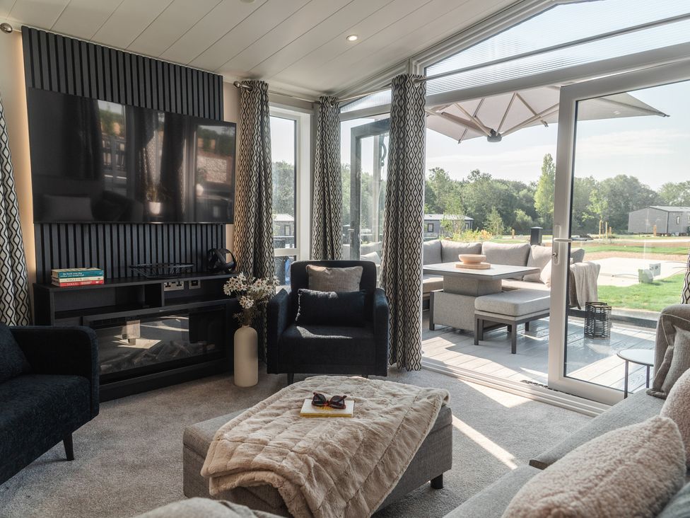 A living room with a television and a sofa at Lakewood Plot 8 in St. Osyth