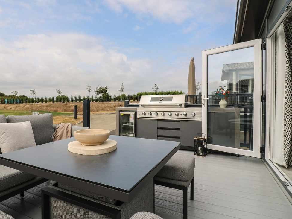 An outdoor patio with a grill and seating area at Lakewood Plot 9 Clacton-on-Sea