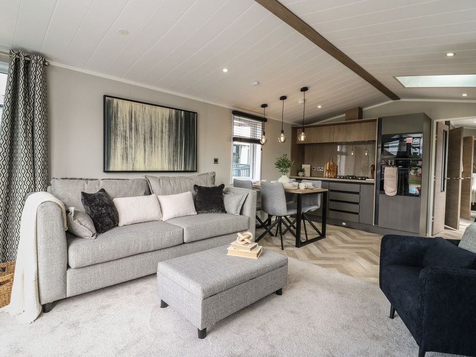 A living room with a sofa and dining area at Lakewood Plot 9 Clacton-on-Sea