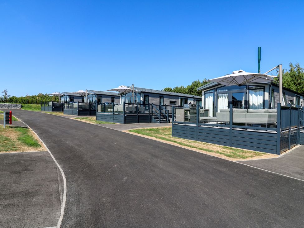Holiday homes with outdoor seating and a pathway at Lakewood Plot 9 St. Osyth