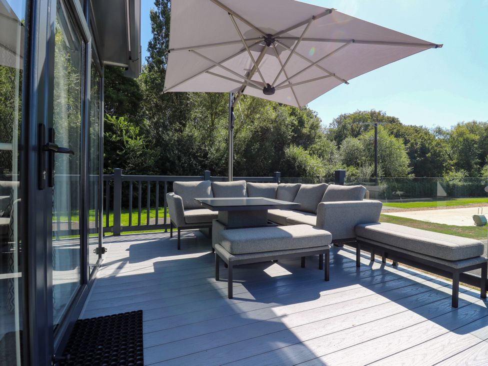 An outdoor patio with a sofa and table at Lakewood Plot 9 in St. Osyth