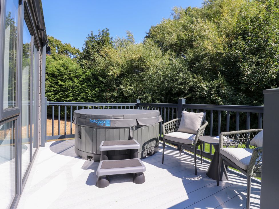 An outdoor area with a hot tub and chairs at Lakewood Plot 9 in St. Osyth
