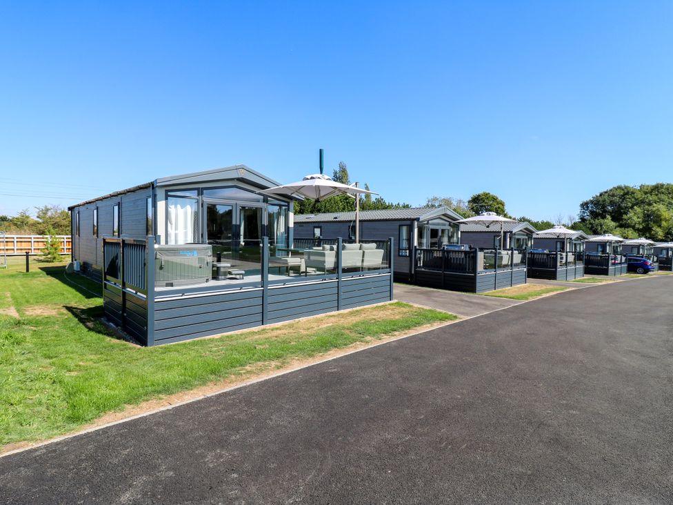 A row of holiday homes with decking and outdoor furniture at Lakewood Plot 9 St. Osyth