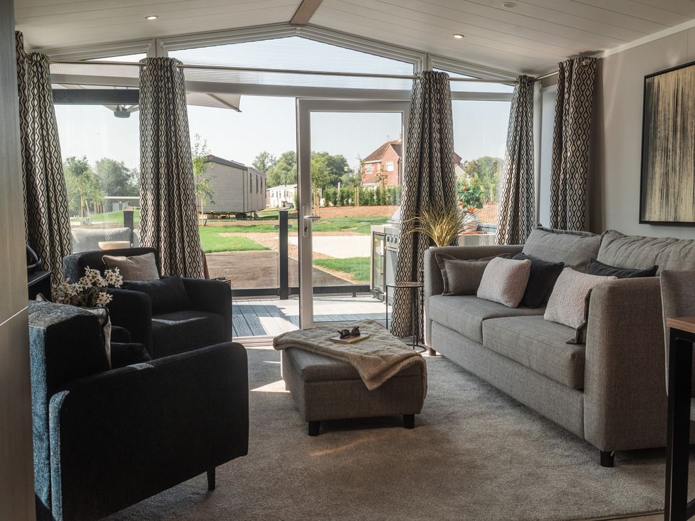A living room with a sofa and armchair at Lakewood Plot 9 in St. Osyth