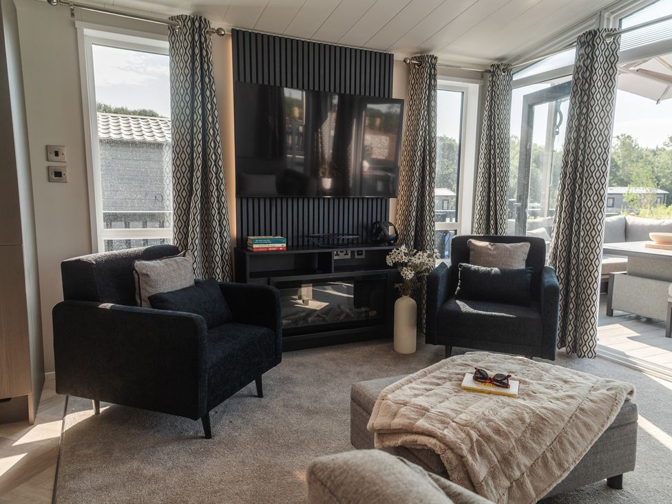 A living room with a television and armchairs at Lakewood Plot 9 St. Osyth
