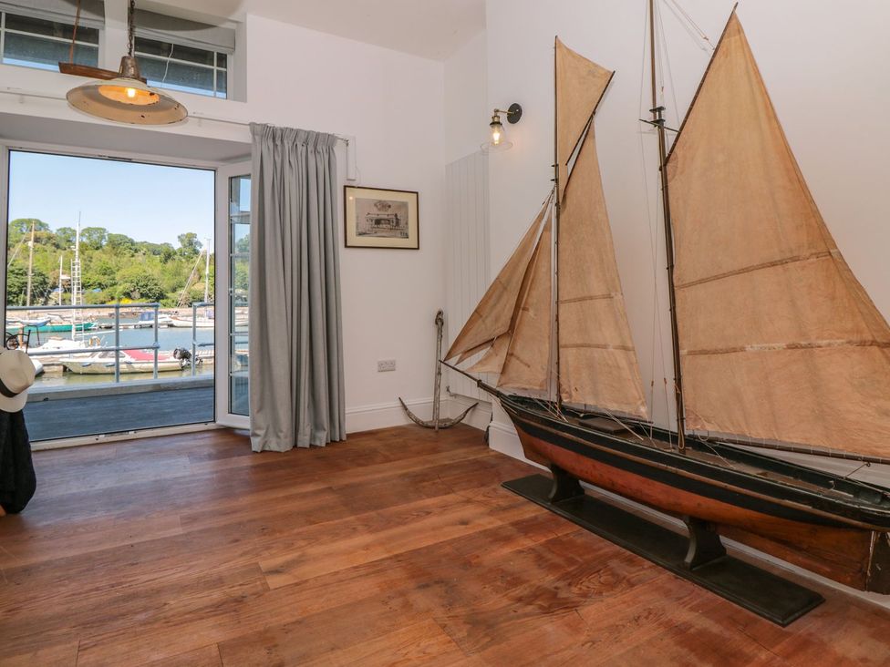 A room with a sailing boat model and a view of the marina at Shipwrights Brixham