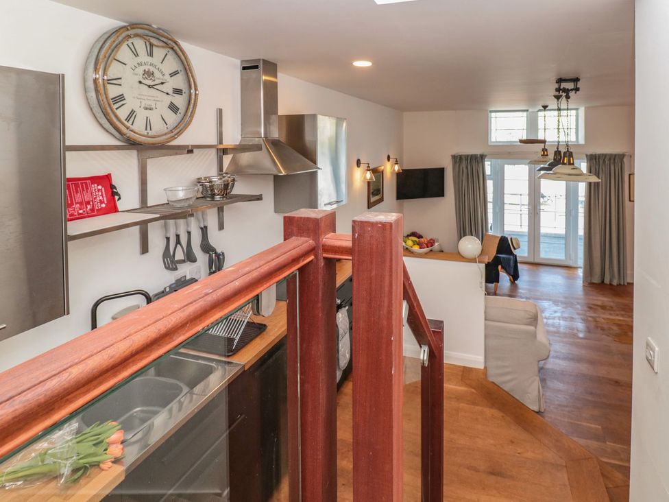 A kitchen with wooden flooring and modern appliances at Shipwrights in Brixham