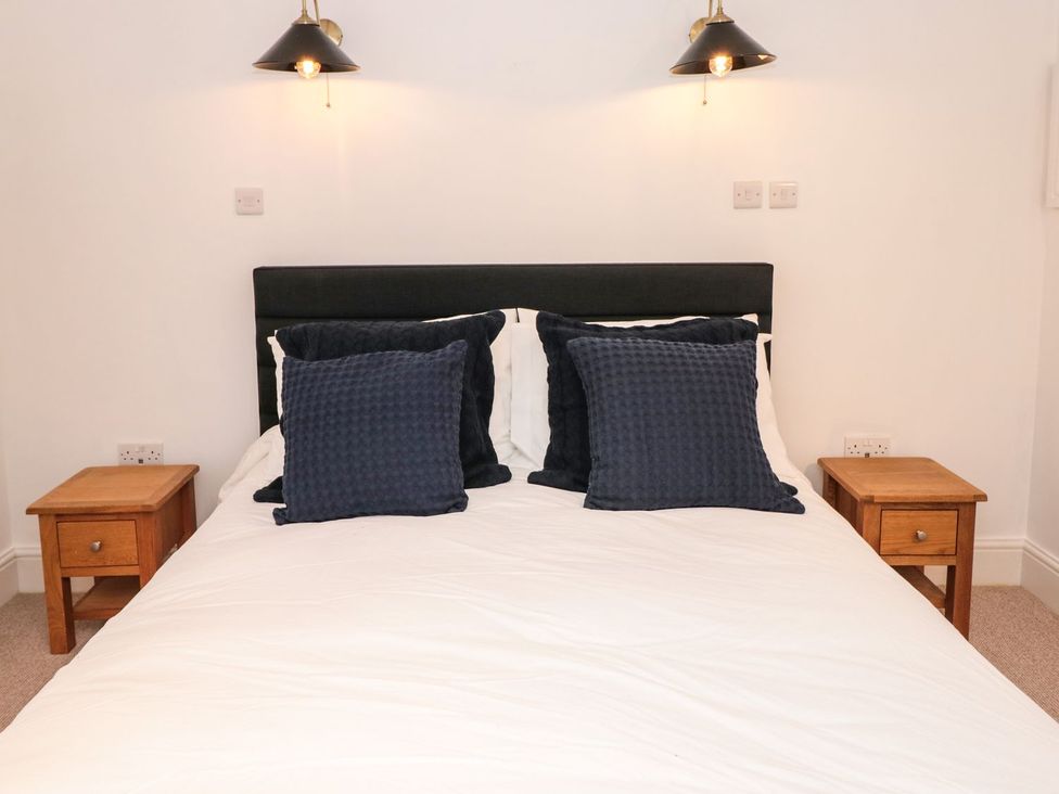 A bedroom with a bed and bedside tables at Shipwrights in Brixham