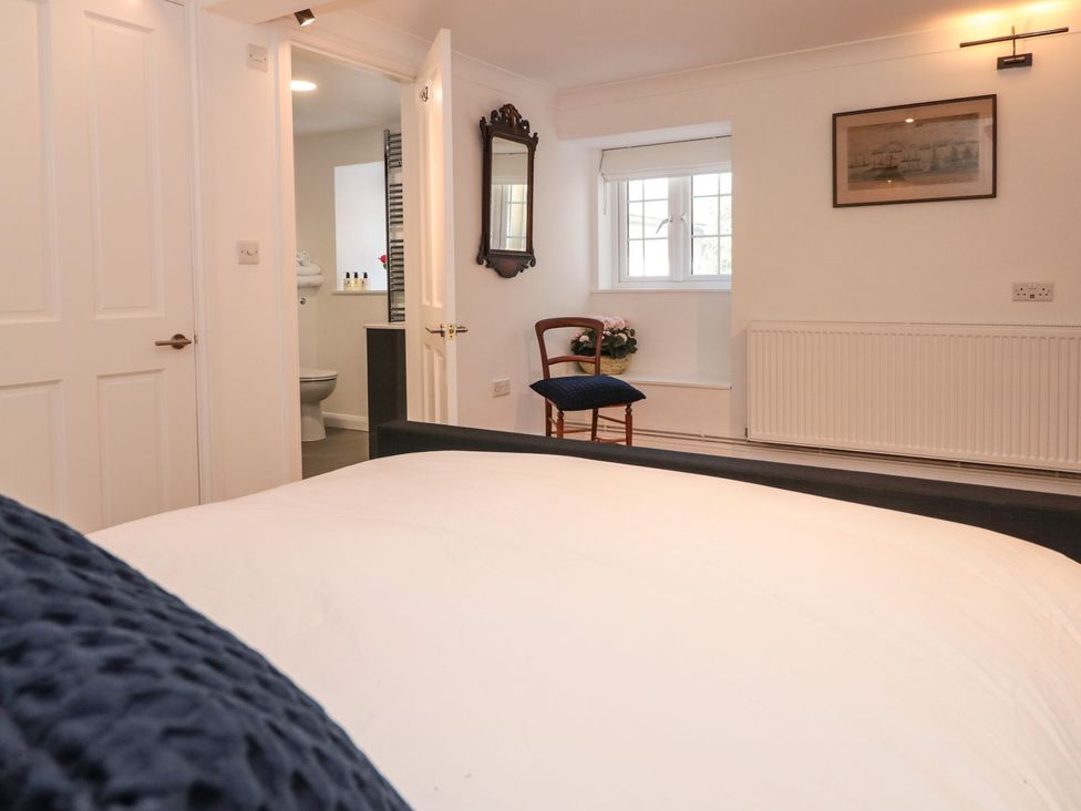 A bedroom with a bed and chair at Shipwrights Brixham