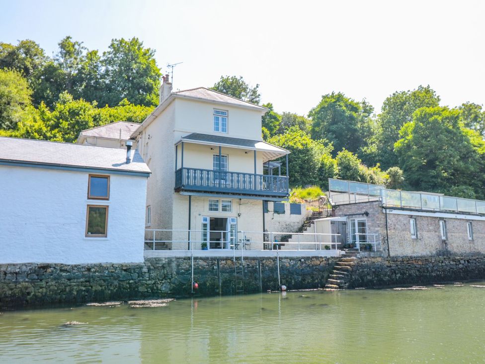 A house with a balcony and steps by the water at Shipwrights in Brixham