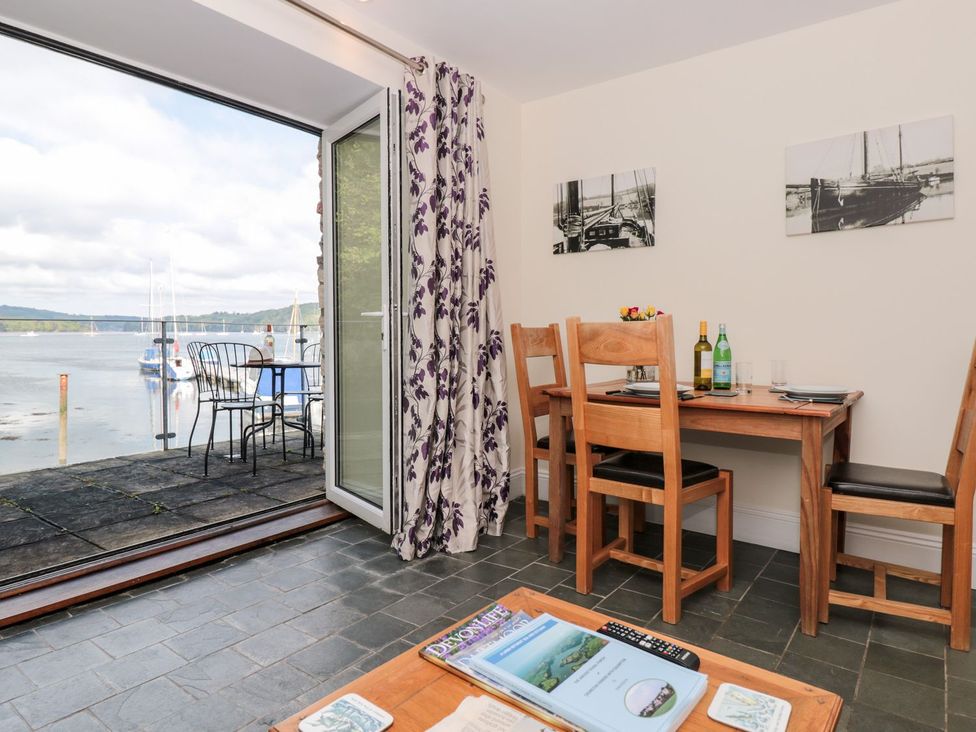 A dining room with a table and chairs at Spanish Boathouse in Brixham