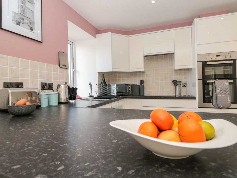 A kitchen with a bowl of fruit and appliances at Spanish Boathouse in Brixham
