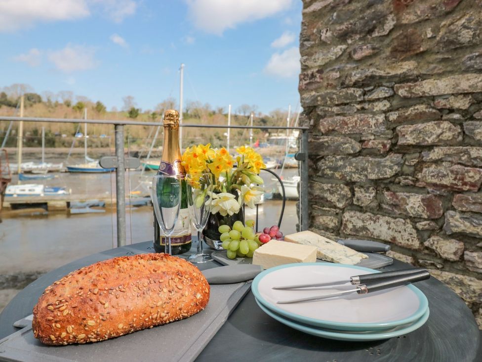 A table with bread, cheese, champagne, and flowers at Spanish Boathouse in Brixham