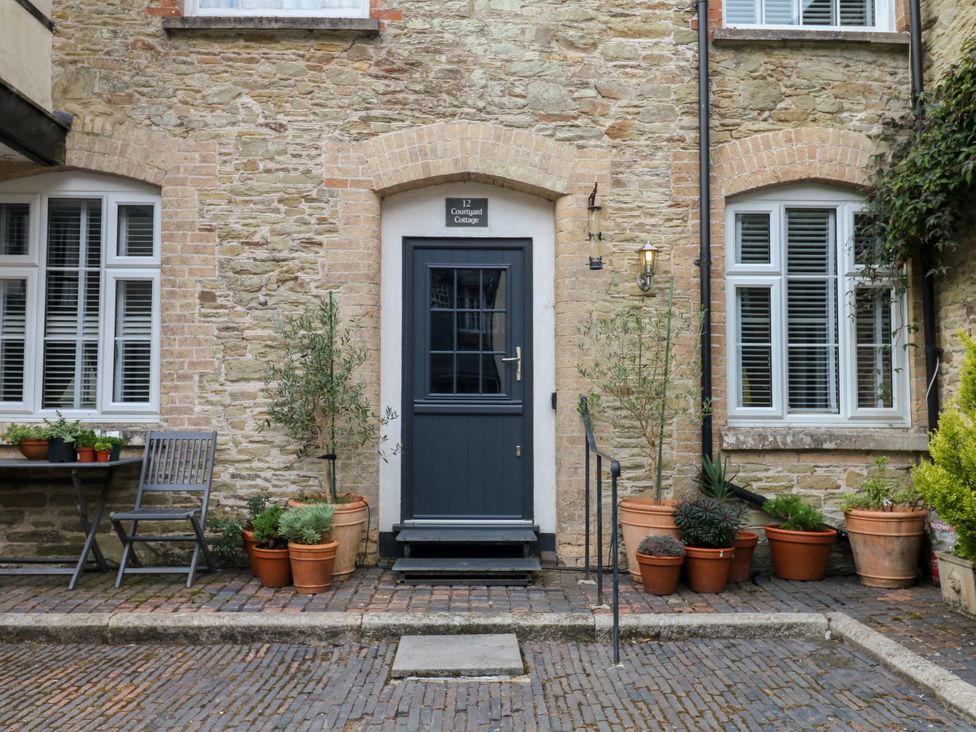 An outdoor area with a door and plants at 12 Courtyard Cottage at Sheplegh Court in Totnes