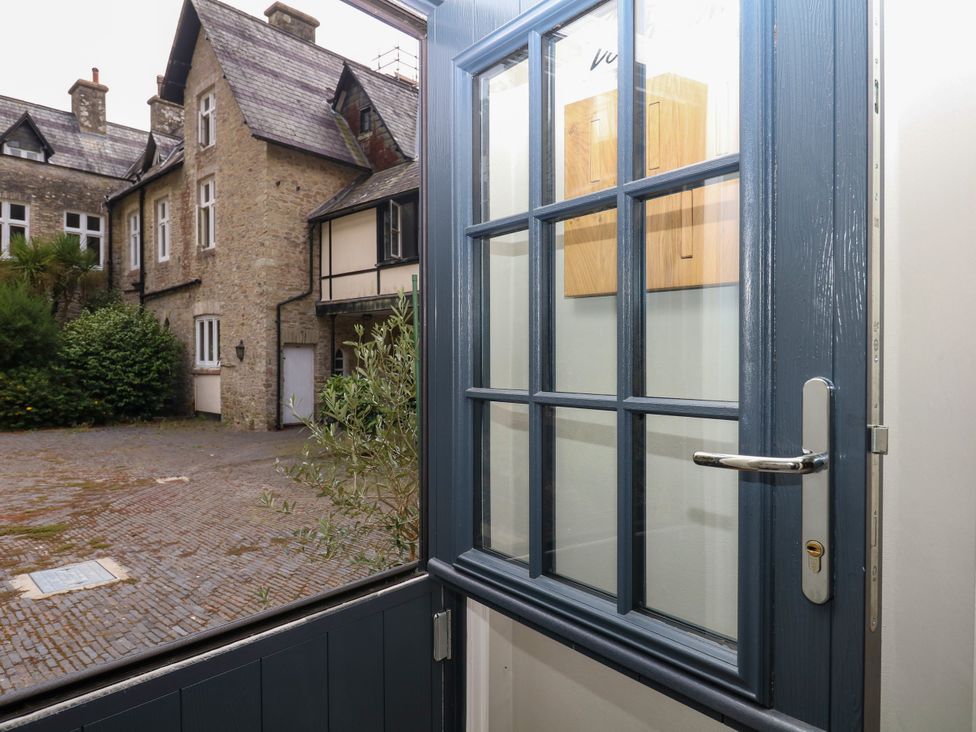 An entrance area with a door opening to a courtyard at 12 Courtyard Cottage at Sheplegh Court in Totnes