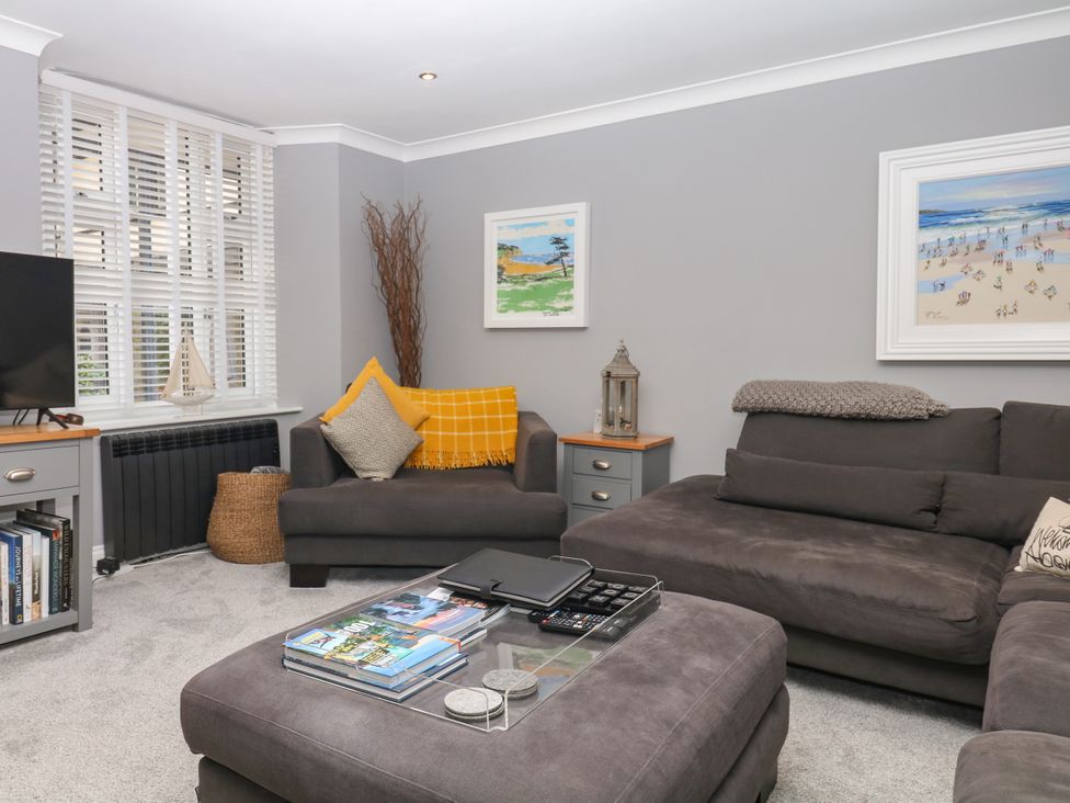A living room with a sofa and television at 12 Courtyard Cottage at Sheplegh Court, Totnes