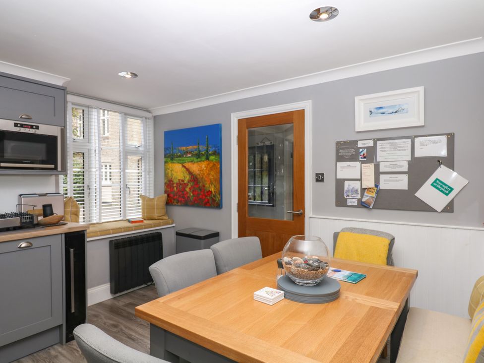 A kitchen with a dining table and chairs at 12 Courtyard Cottage at Sheplegh Court Totnes