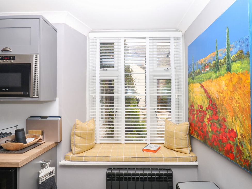 A kitchen with a seating area by the window at 12 Courtyard Cottage at Sheplegh Court in Totnes