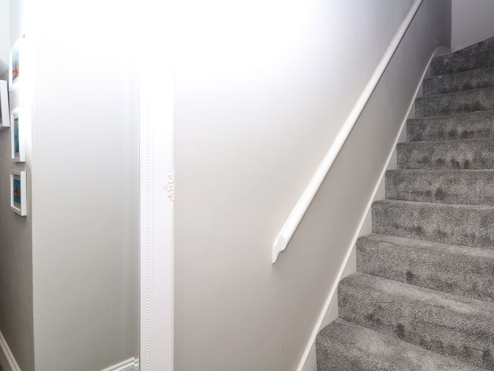 A staircase leading upstairs in the hallway at 12 Courtyard Cottage at Sheplegh Court in Totnes