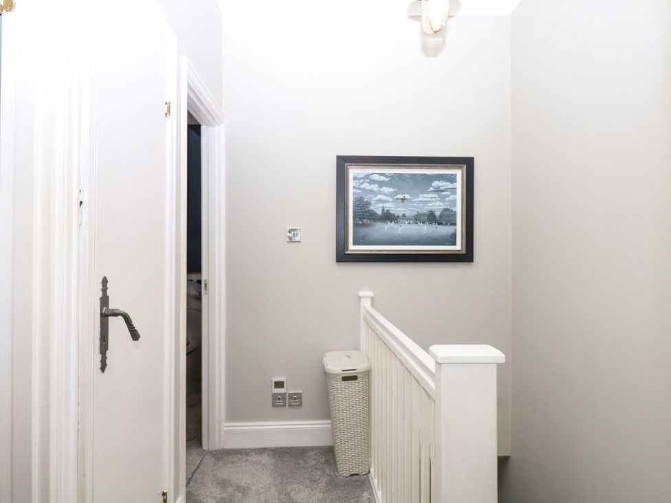 A hallway with a picture frame and storage basket at 12 Courtyard Cottage at Sheplegh Court in Totnes