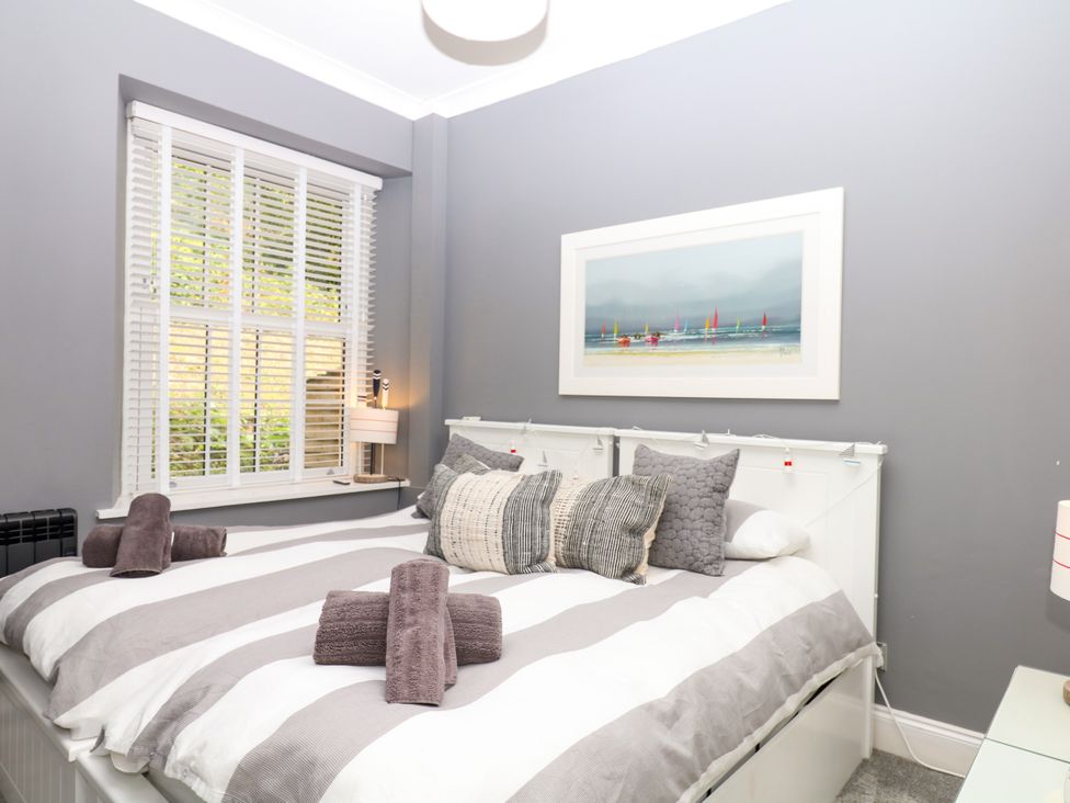 A bedroom with a bed, pillows, and a window at 12 Courtyard Cottage at Sheplegh Court, Totnes
