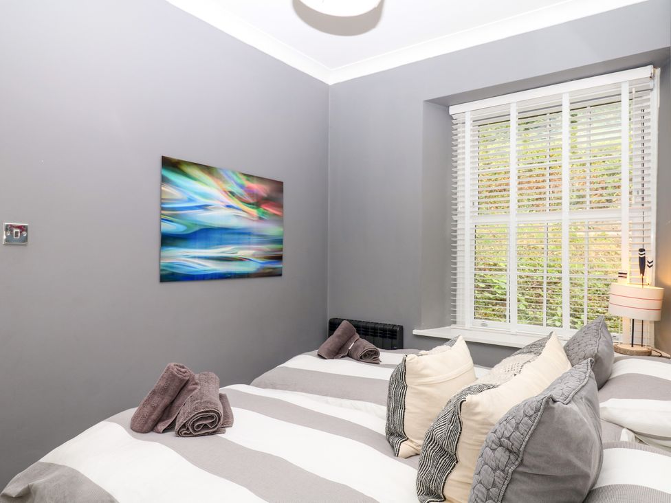 A bedroom with two beds and decorative pillows at 12 Courtyard Cottage at Sheplegh Court in Totnes
