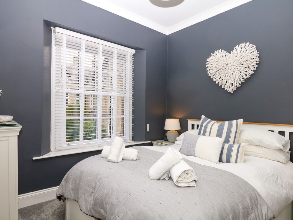 A bedroom with a bed and window at 12 Courtyard Cottage at Sheplegh Court in Totnes