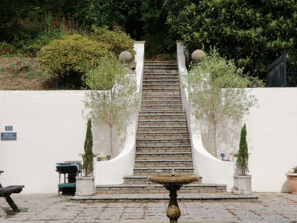 A staircase leading to a garden with trees at 12 Courtyard Cottage at Sheplegh Court in Totnes