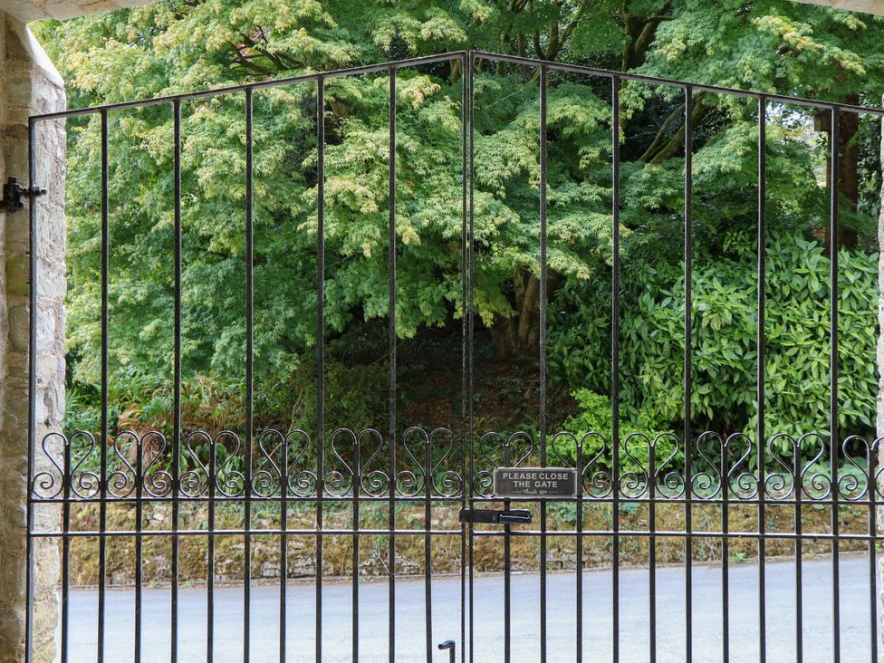 A gate with trees in the background at 12 Courtyard Cottage at Sheplegh Court Totnes