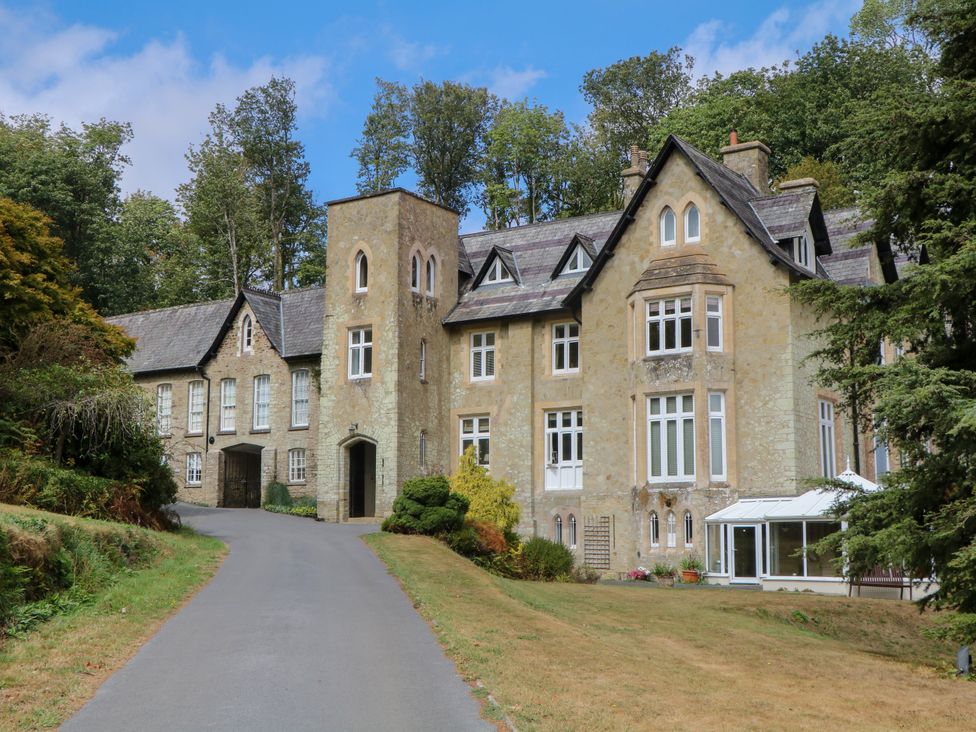 A building with multiple windows and a driveway at 12 Courtyard Cottage at Sheplegh Court in Totnes
