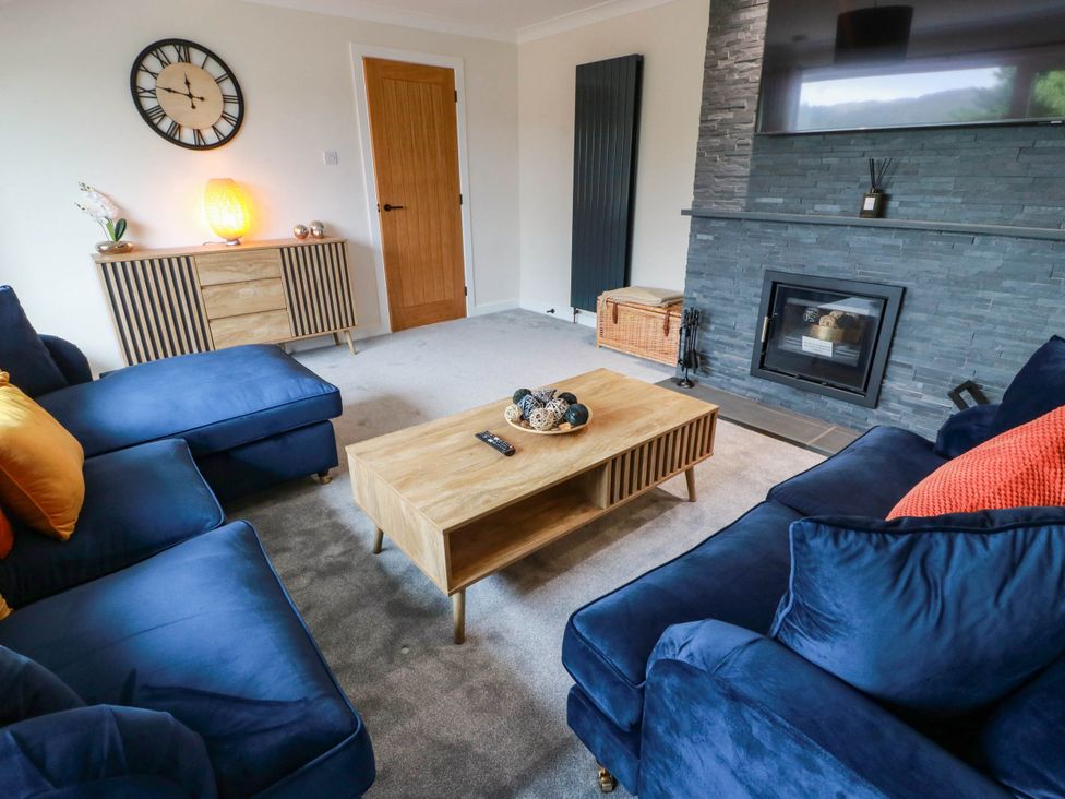 A living room with a sofa and coffee table at Camusfearna in Dalbeattie