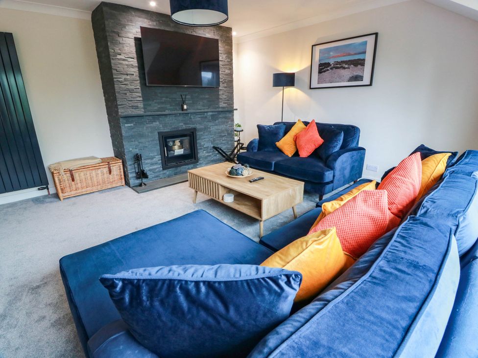 A living room with a blue sofa and a coffee table at Camusfearna in Dalbeattie
