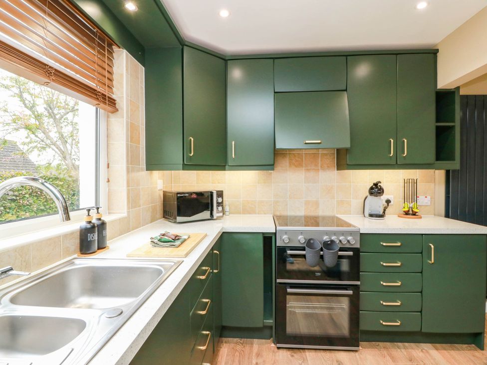 A kitchen with cabinets and appliances at Camusfearna in Dalbeattie