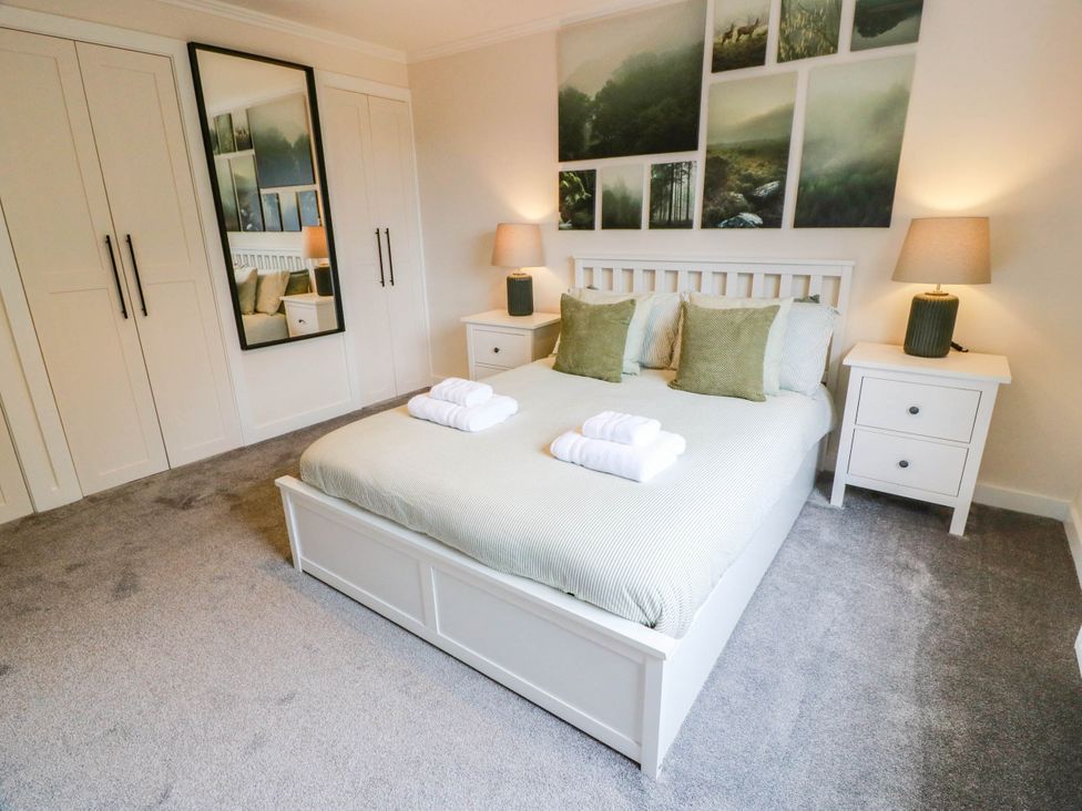 A bedroom with a double bed and wardrobe at Camusfearna in Dalbeattie