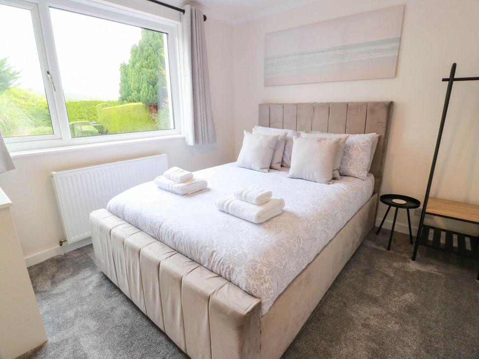A bedroom with a bed and window at Camusfearna in Dalbeattie