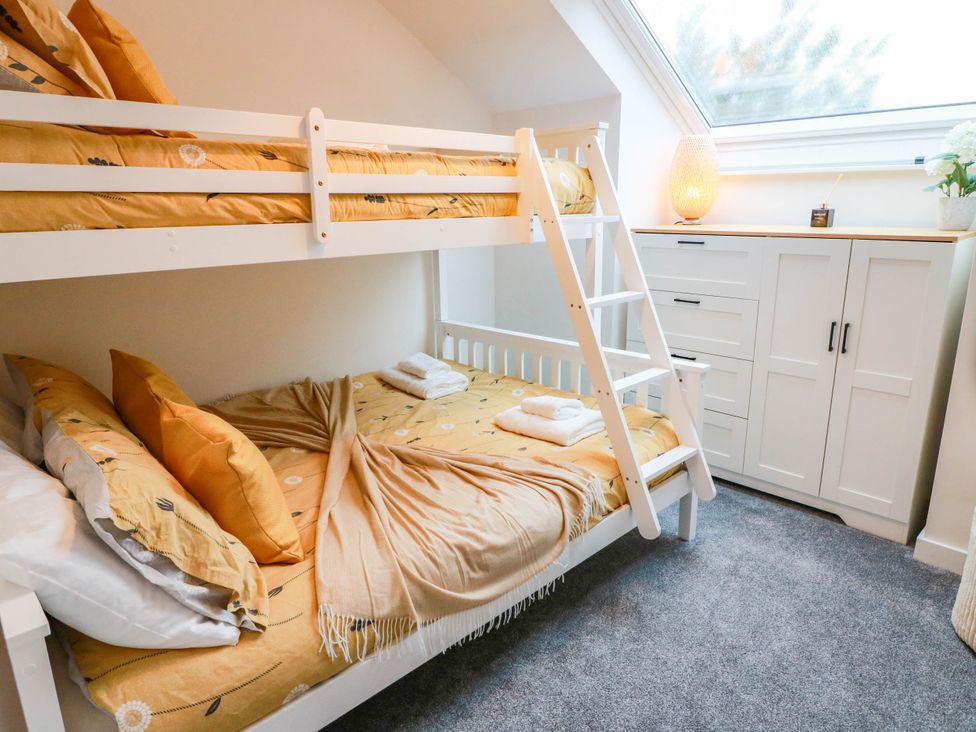 A bedroom with a bunk bed and dresser at Camusfearna in Dalbeattie