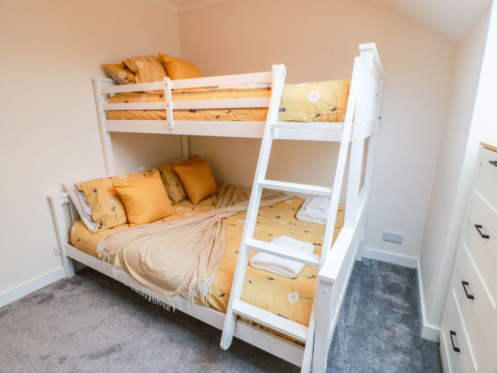 A bedroom with a bunk bed and a dresser at Camusfearna in Dalbeattie