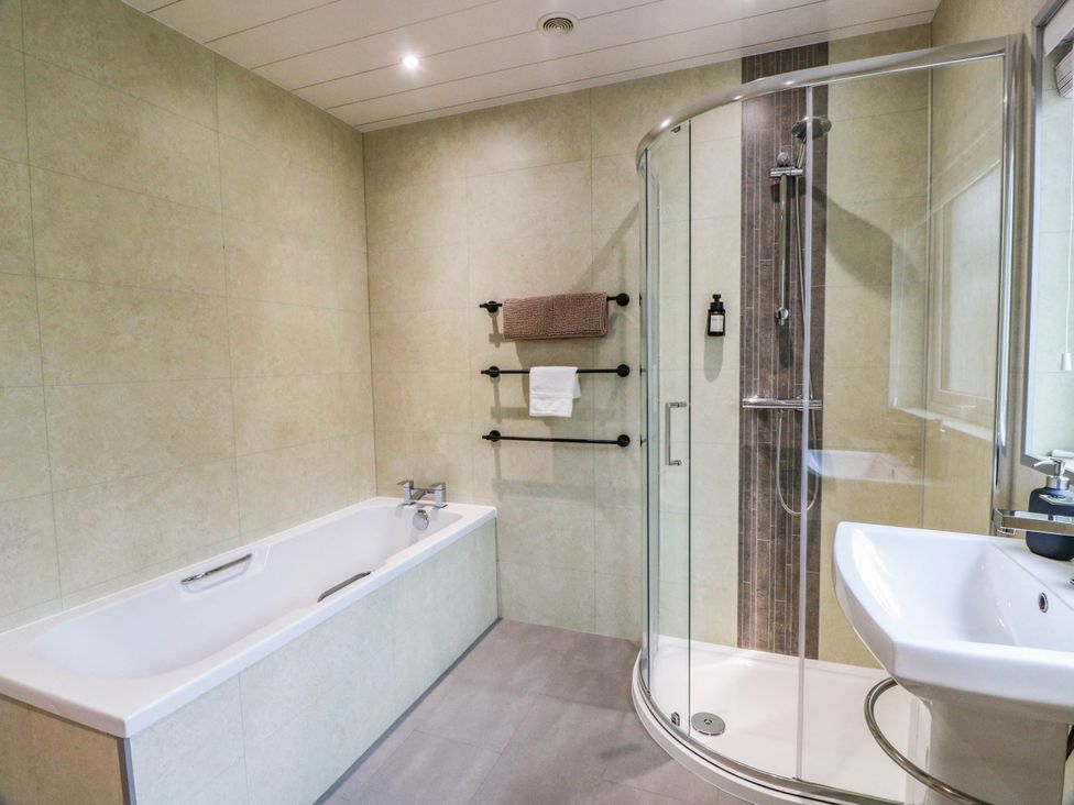 A bathroom with a bath tub and shower at Camusfearna in Dalbeattie