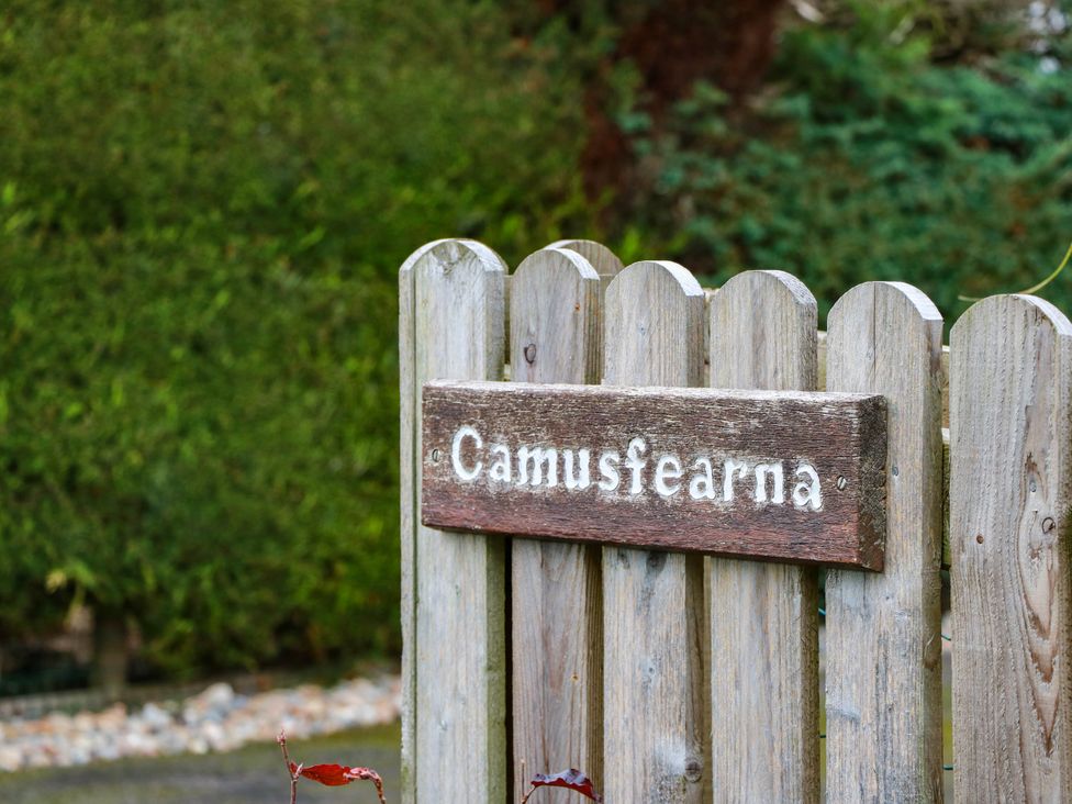 A wooden sign on a fence at Camusfearna in Dalbeattie