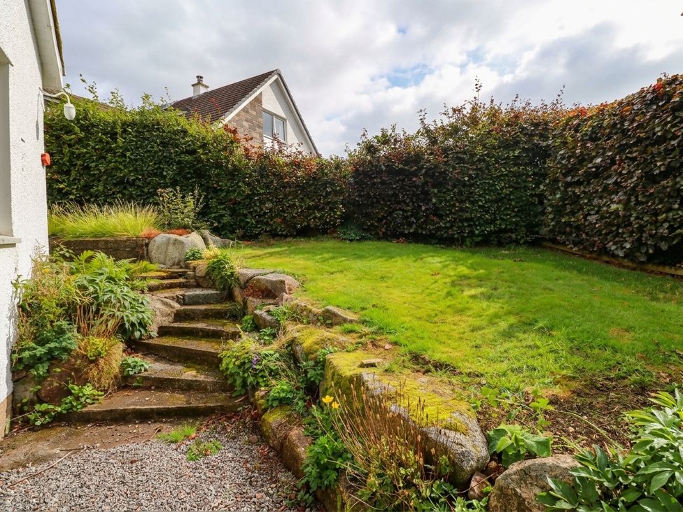 A garden with steps and grass at Camusfearna in Dalbeattie