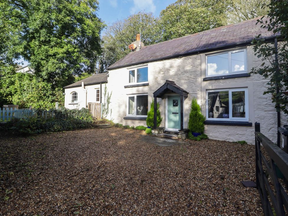 A house with a gravel area and trees at Ty'r Wennol in Fishguard